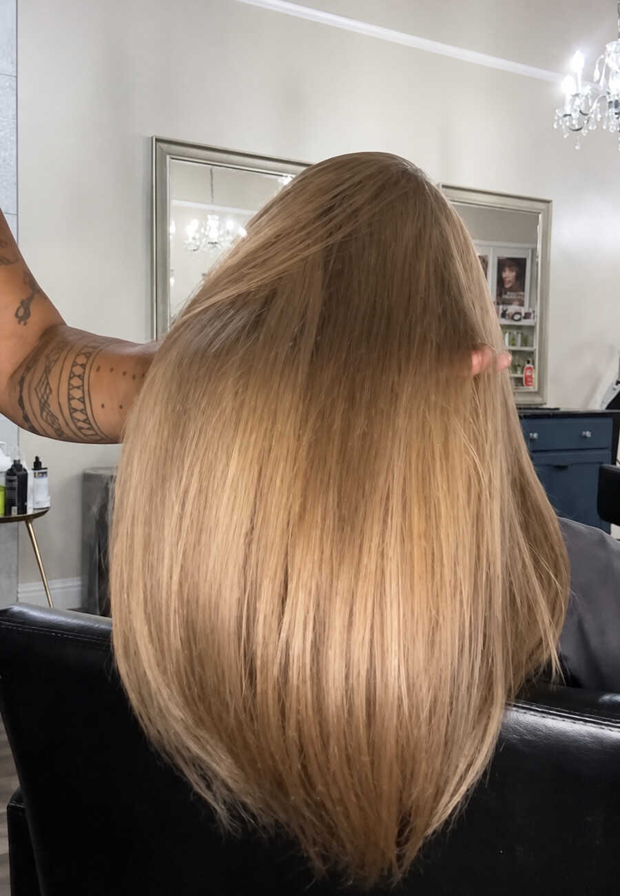 Long caramel blonde hair, glossy and cut blunt at the ends