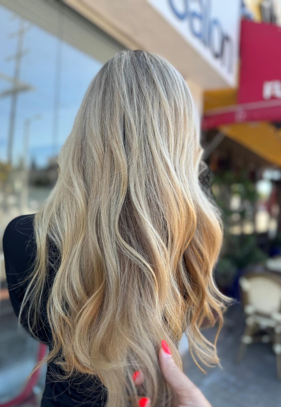 Long ash-blonde hair with a soft grown-out root, shot in daylight