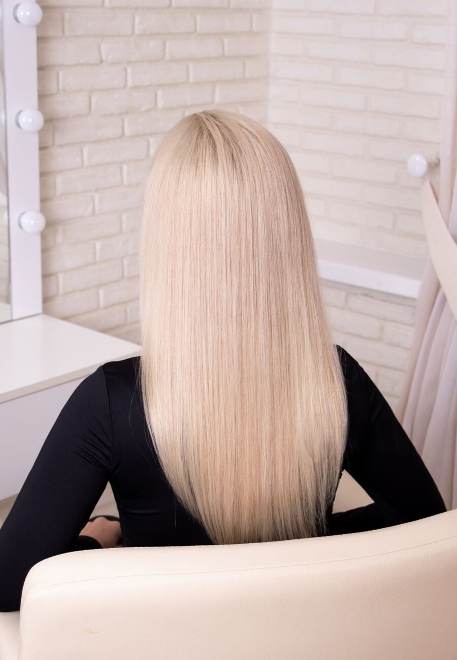 Platinum blonde hair, straight and glassy, photographed from behind