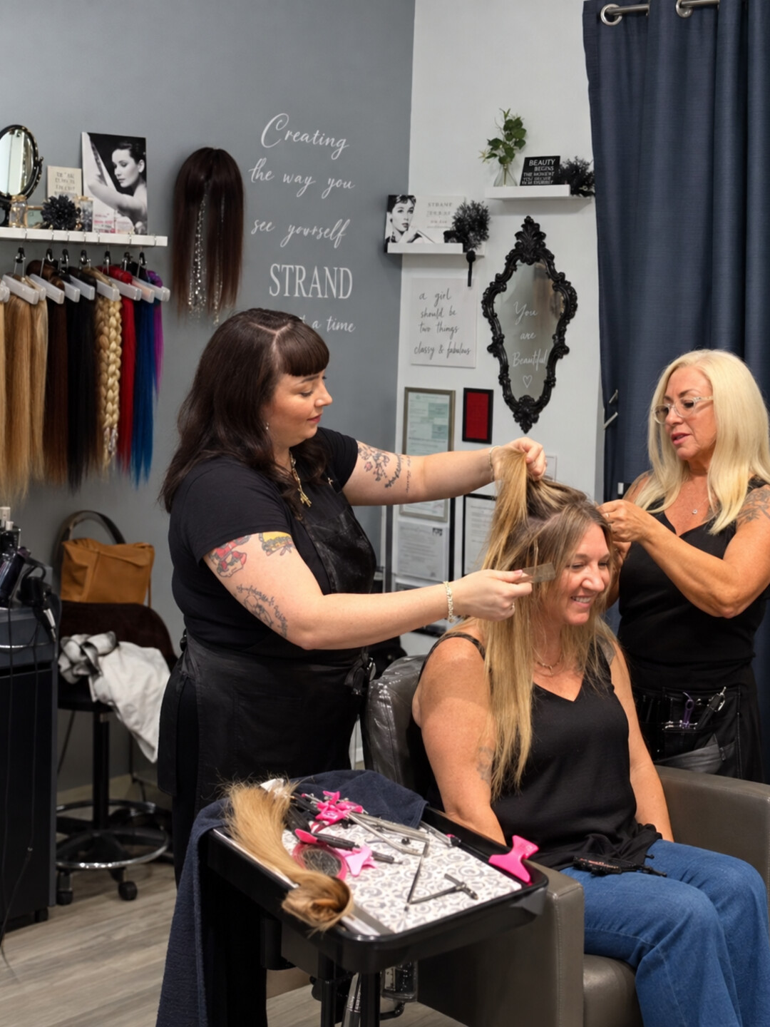 A stylist working on a seated client’s hair in the salon