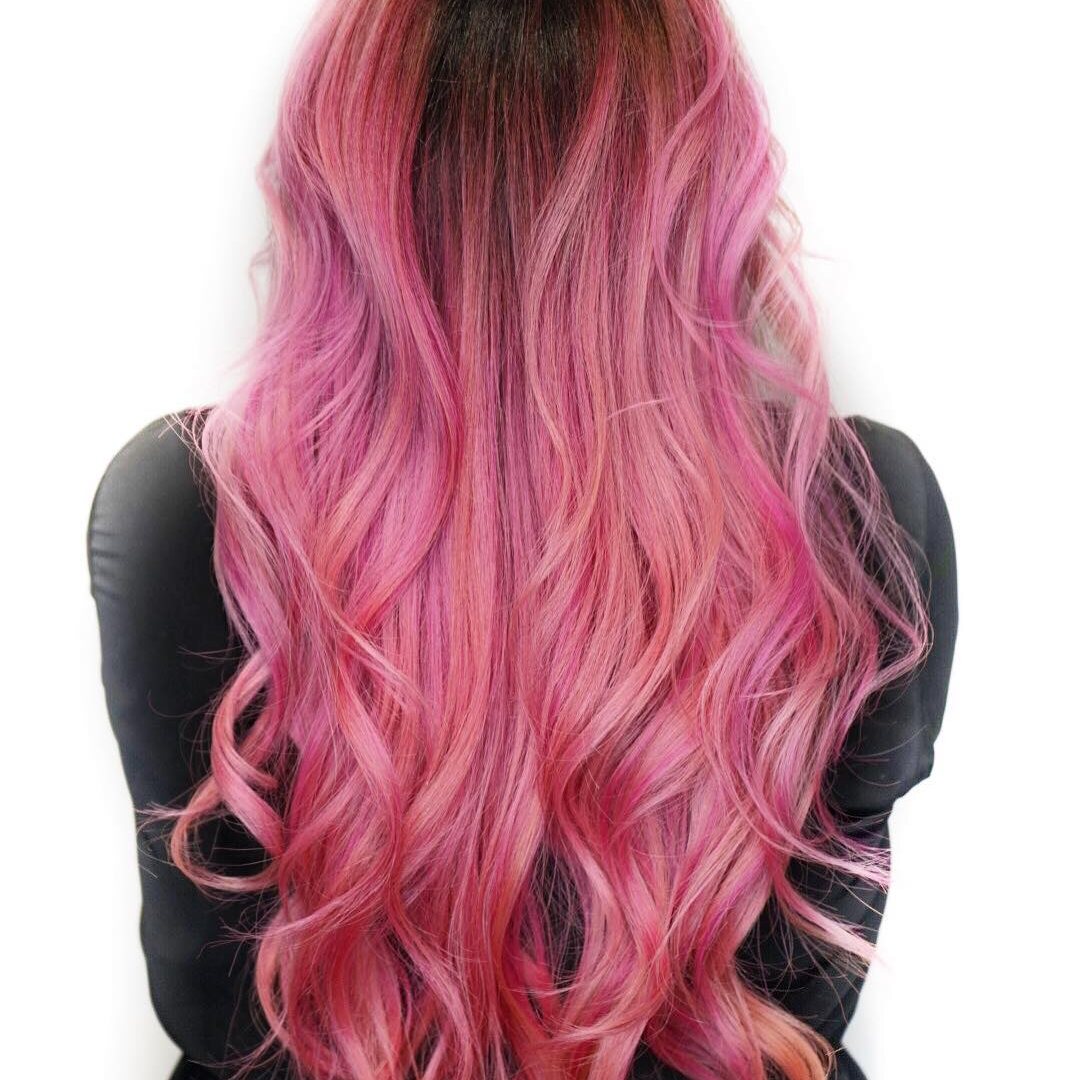 Pink waves over a dark root, seen from behind