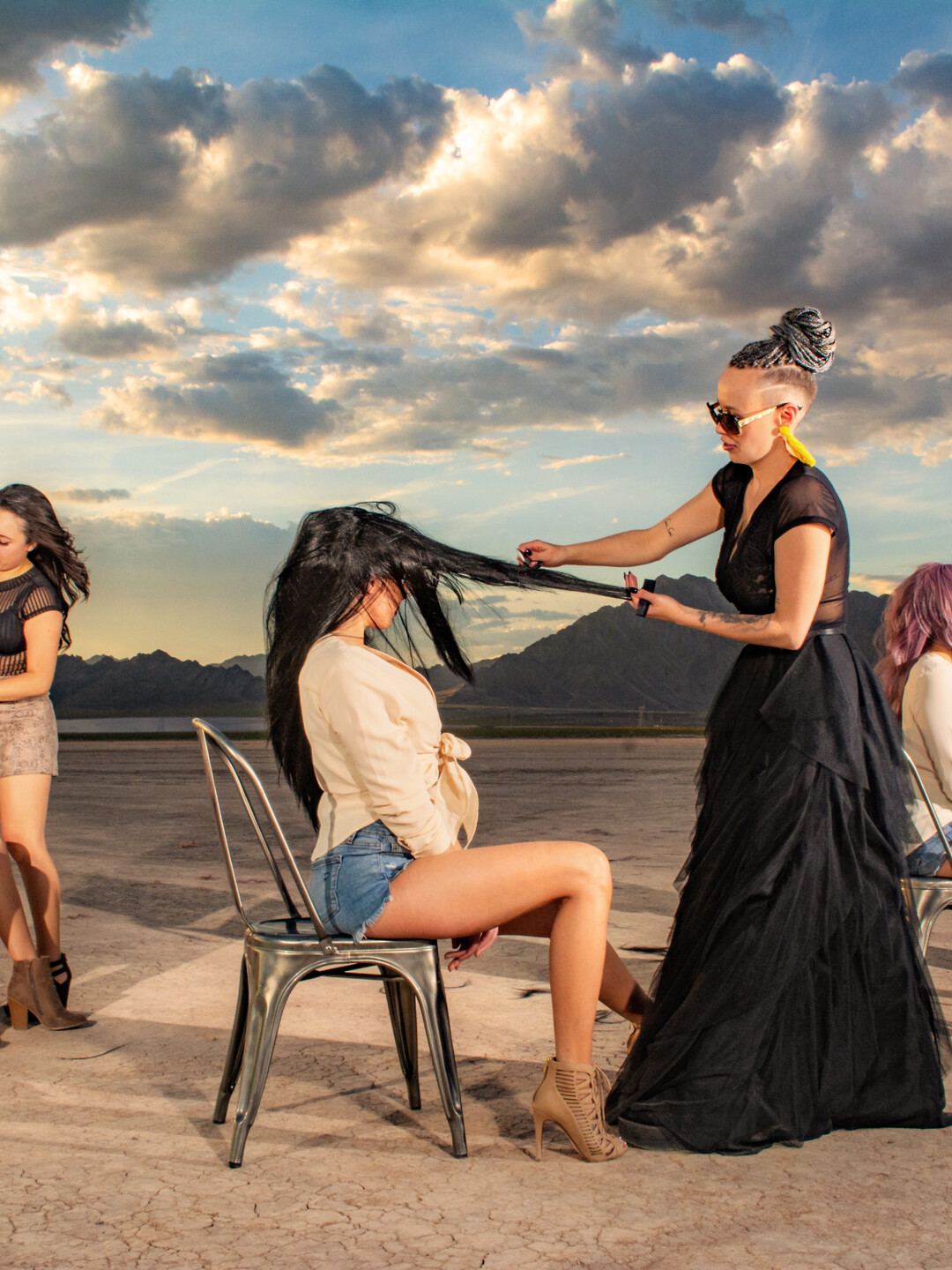 Tzigane working on a seated model’s hair during an outdoor shoot