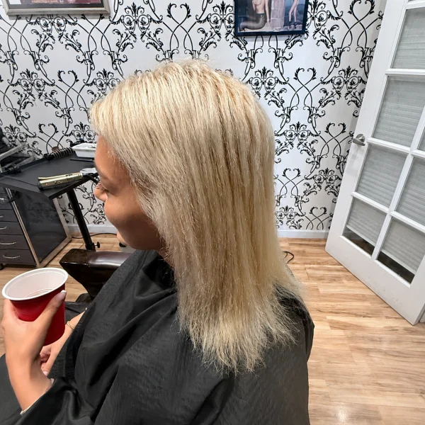 Before: shoulder-length blonde in a salon cape
