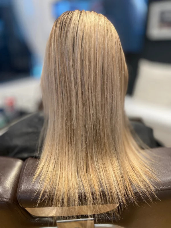 Smooth blonde extensions photographed from behind at Vered Salon