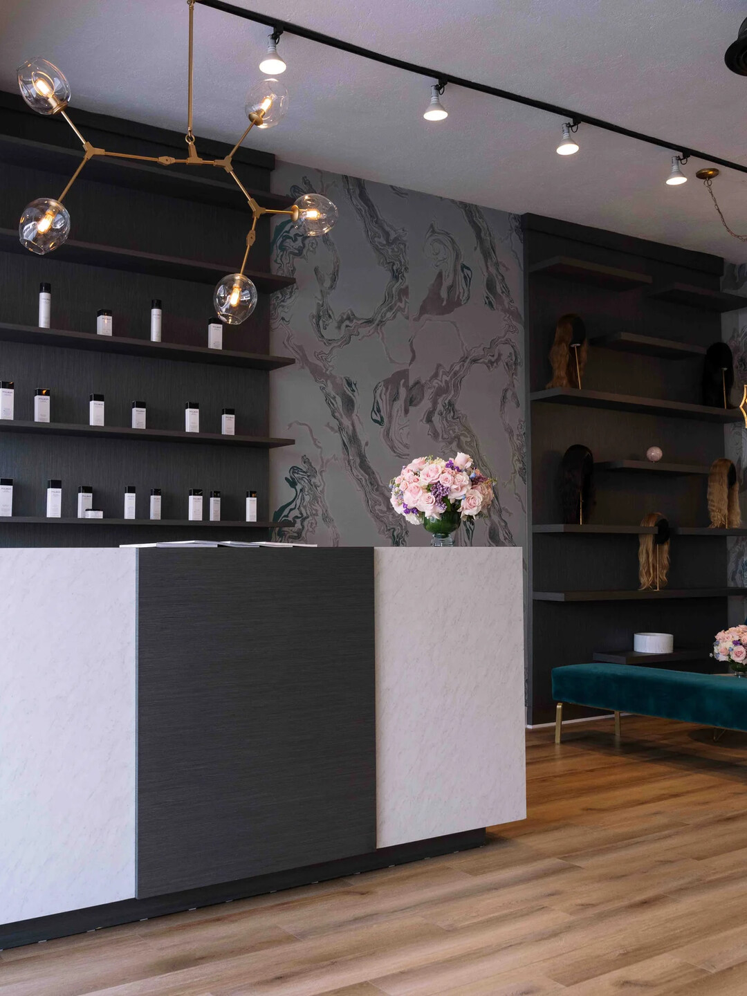 The reception at Hair by Violet: velvet seating, wood floor, a wall of hair
